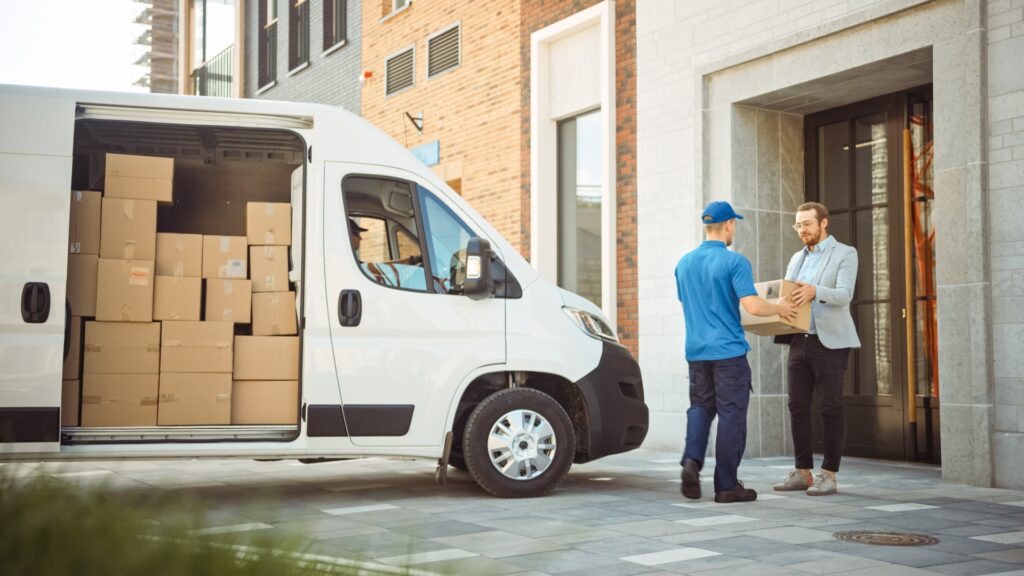 A delivery person hands a package to a man