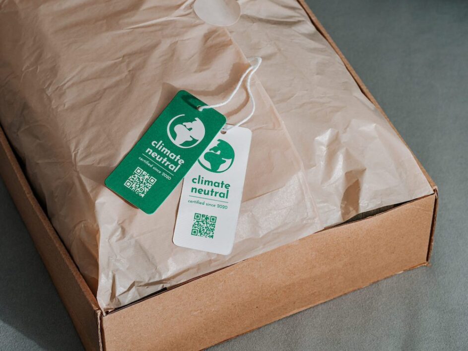 A cardboard box filled with recycled tissue, accompanied by an eco-friendly tag depicting sustainable packaging for ecommerce deliveries